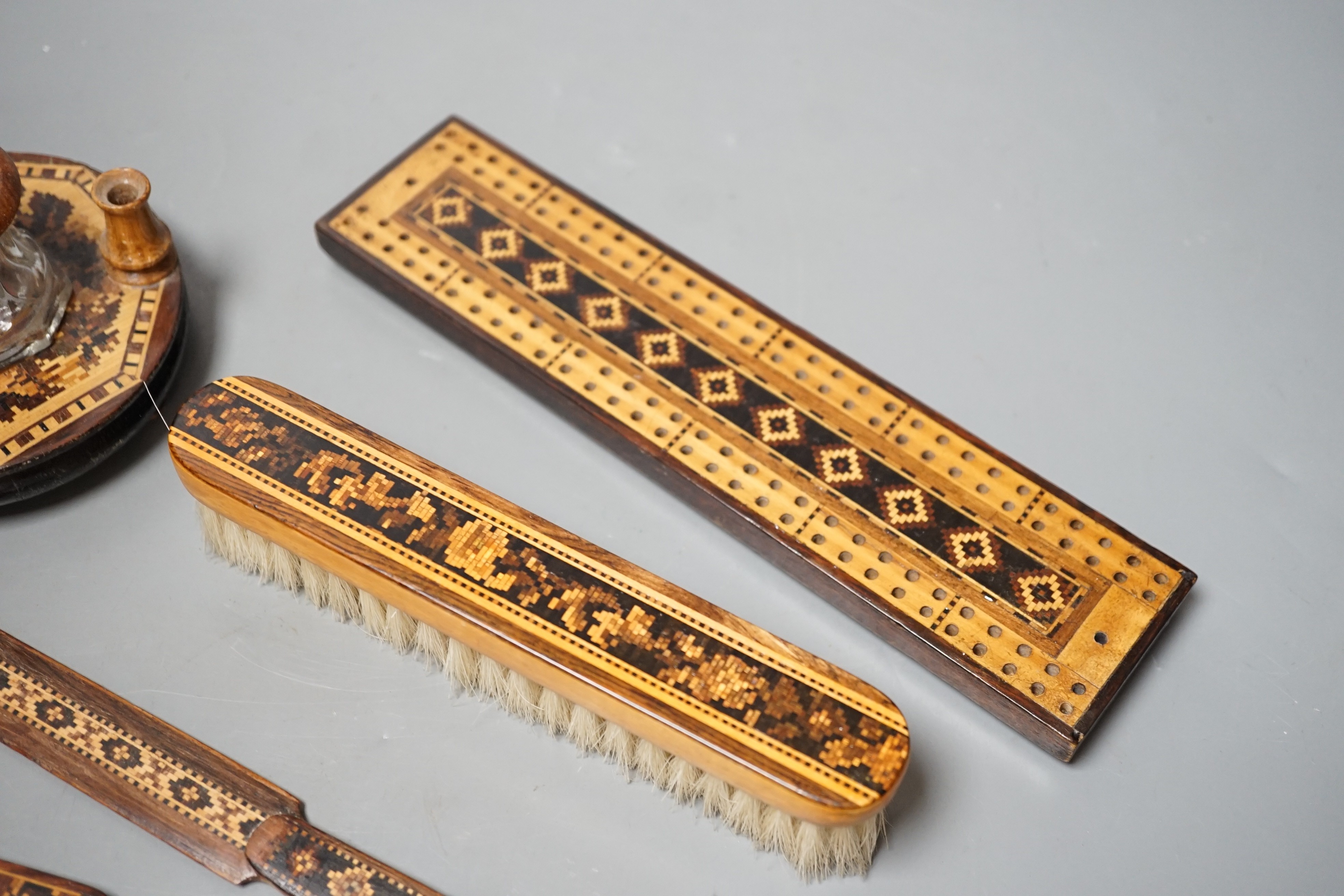 A group of Tunbridge ware to include an inkstand, two paper knives (one a handle only), cribbage board, a brush and a brooch